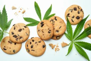 Cannabis leaves and cookies on white background