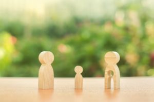 Child’s figure stands between father and mother