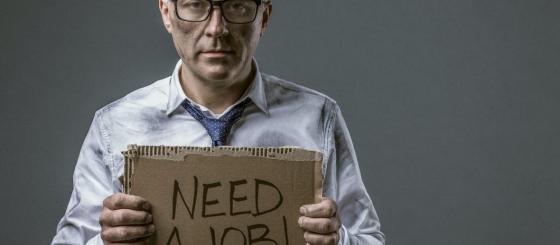 Broke jobless businessman holding a cardboard sign