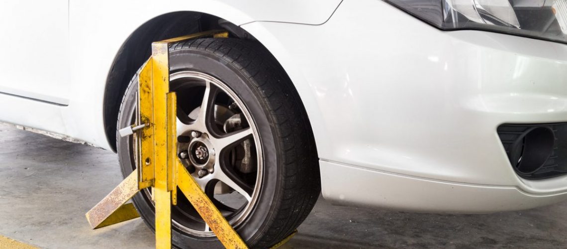 Car wheel clamped for illegal parking violation at car park