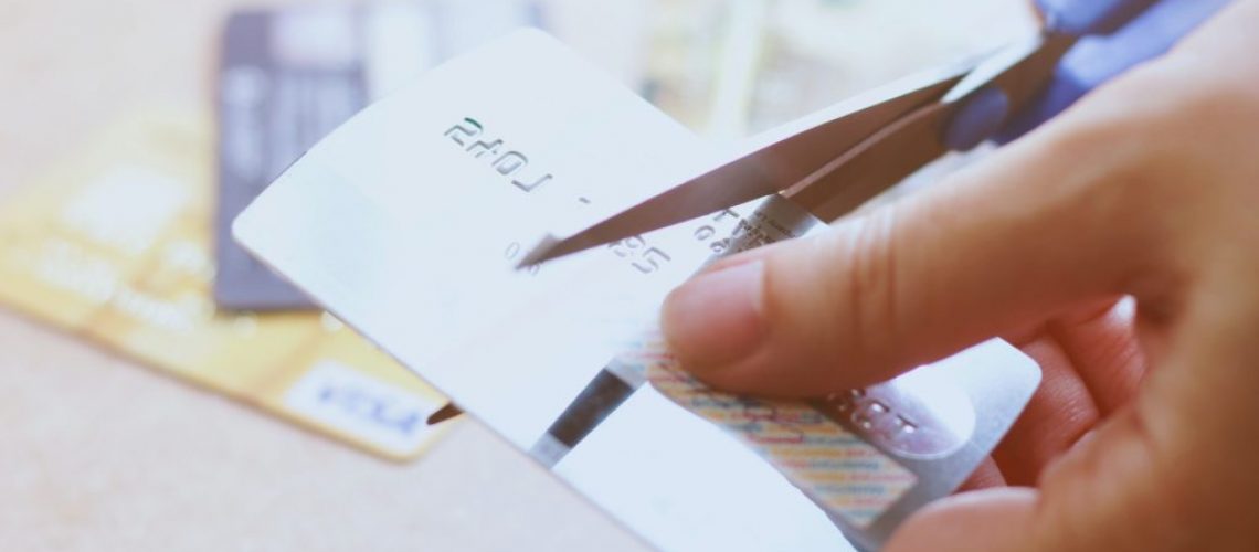 Hand cutting credit card with scissors