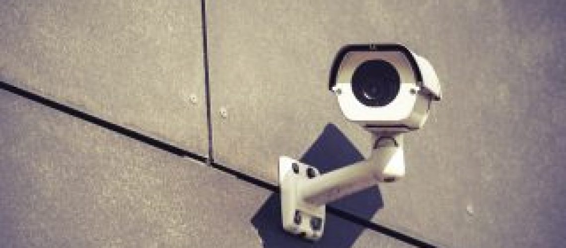 Security camera on gray office building wall