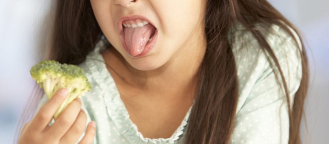 Unhappy Young Girl Rejecting Plate Of Fresh Vegetables